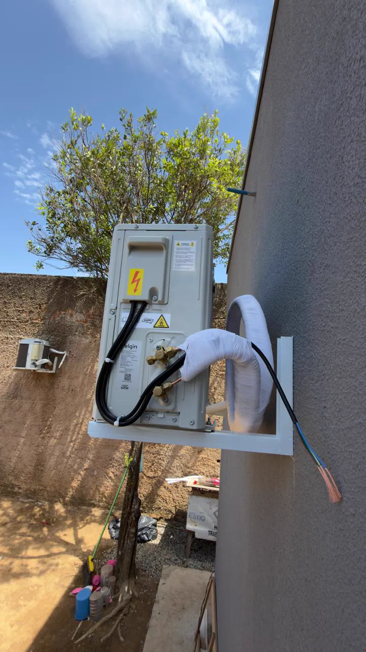 Condensadora em suporte de parede com a tubulação isolada.