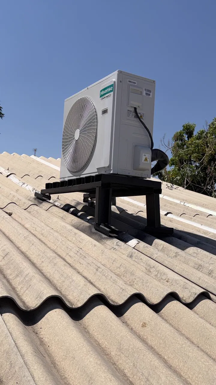 Condensadora Hisense instalada sobre suporte em cima de um telhado.